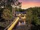 Waterfront home featuring a private dock with water access amidst lush greenery at twilight at 3610 Legareville Rd, Johns Island, SC 29455