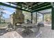 Outdoor kitchen with pizza oven, grill, and dining area under a pergola, ideal for al fresco dining at 3610 Legareville Rd, Johns Island, SC 29455