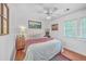 Cozy bedroom features hardwood floors, ceiling fan, and bright natural light from the double window at 364 Dupre Rd, McClellanville, SC 29458