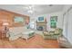 Comfortable living room featuring wood floors, fireplace with artwork, and lots of natural light at 364 Dupre Rd, McClellanville, SC 29458
