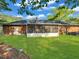 Backyard with a red brick home featuring a screened-in porch at 411 Red Fox Run, Summerville, SC 29485