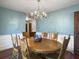 Dining room featuring a wooden table, chandelier, and aqua walls with white wainscotting at 411 Red Fox Run, Summerville, SC 29485