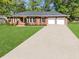 Inviting brick home with an expansive driveway and well-manicured lawn offering great curb appeal at 411 Red Fox Run, Summerville, SC 29485