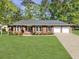 Charming single story brick home featuring an attached two car garage and lush green lawn at 411 Red Fox Run, Summerville, SC 29485