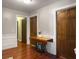 Hallway with warm wood floors, classic wainscoting, and vintage Singer sewing table at 411 Red Fox Run, Summerville, SC 29485