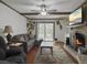 Inviting living room with a cozy fireplace, hardwood floors, ceiling fan, and access to the outdoor patio at 411 Red Fox Run, Summerville, SC 29485