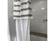 Shower featuring white subway tile and glass door with tan and white striped shower curtain at 411 Red Fox Run, Summerville, SC 29485