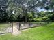 Outdoor dog park area with secure fencing, green grass, shady trees and comfortable seating for pet owners at 415 Parkdale Dr # 12D, Charleston, SC 29414