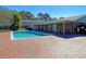 Community pool surrounded by a brick patio and lush greenery at 415 Parkdale Dr # 12D, Charleston, SC 29414
