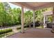 Spacious covered balcony with black iron railings offers serene views of the surrounding lush greenery at 421 Royal Assembly Dr, Charleston, SC 29492