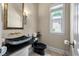 Stylish powder room featuring a black stone vessel sink and designer fixtures at 421 Royal Assembly Dr, Charleston, SC 29492