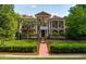 Elegant two-story home with manicured lawn, palm trees and a brick walkway leading to the front door at 421 Royal Assembly Dr, Charleston, SC 29492
