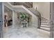 Elegant foyer with a curved staircase, marble floors, and decorative accents at 421 Royal Assembly Dr, Charleston, SC 29492