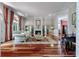 A spacious living room featuring hardwood floors, a fireplace, and large windows with decorative drapes at 421 Royal Assembly Dr, Charleston, SC 29492