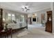Bright main bedroom with four-poster bed, neutral carpet, and large windows with backyard view at 421 Royal Assembly Dr, Charleston, SC 29492