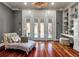 Bright sitting room with hardwood floors, french doors leading to pool area, and stylish decor and built-in bookshelves at 421 Royal Assembly Dr, Charleston, SC 29492