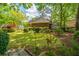 Backyard view with well-maintained lawn, mature trees, and colorful bushes that create a peaceful outdoor setting at 4403 Wild Thicket Ln, North Charleston, SC 29420