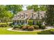 Two-story home with charming curb appeal, lush landscaping, and a welcoming front porch at 4403 Wild Thicket Ln, North Charleston, SC 29420