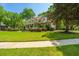 Charming two-story home with a landscaped yard, inviting front porch, and mature trees under a clear blue sky at 4403 Wild Thicket Ln, North Charleston, SC 29420