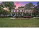 Beautiful two-story home with mature trees and landscaping, showcased at dusk with a colorful sky at 4403 Wild Thicket Ln, North Charleston, SC 29420