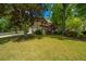 Home with a two-car garage and lush lawn adorned with mature trees and colorful shrubs in a serene setting at 4403 Wild Thicket Ln, North Charleston, SC 29420
