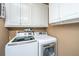 Convenient laundry room equipped with modern washer and dryer, and ample storage cabinets at 4403 Wild Thicket Ln, North Charleston, SC 29420