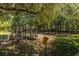 Playground nestled in the trees, with swings and slides that are a safe, fun place for to play at 4403 Wild Thicket Ln, North Charleston, SC 29420
