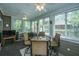 Bright sun room with multiple windows, tiled floors, ceiling fans, fireplace, and a seating area with TV at 4403 Wild Thicket Ln, North Charleston, SC 29420