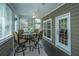 Comfortable sun room with multiple windows, tiled floors, ceiling fan, and seating area near the exterior door at 4403 Wild Thicket Ln, North Charleston, SC 29420