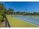 Brightly lit tennis courts with green and blue surfaces, surrounded by lush landscaping and trees at 4403 Wild Thicket Ln, North Charleston, SC 29420