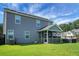 View of backyard with hot tub, lawn, and screened-in porch at 504 Foxbank Plantation Blvd, Moncks Corner, SC 29461