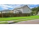Back exterior view showcasing the house, well-kept lawn, wooden fence, and solar panels at 504 Foxbank Plantation Blvd, Moncks Corner, SC 29461
