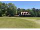 A charming cabin-style home sits majestically on sprawling lawn of this beautiful rural property at 6935 Hickorynut Ln, Ravenel, SC 29470