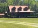 A rustic log cabin-style home with a red metal roof and a welcoming porch exudes charm at 6935 Hickorynut Ln, Ravenel, SC 29470
