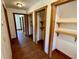 Hallway featuring hardwood flooring and built-in closets, leading to bedrooms and other rooms at 6935 Hickorynut Ln, Ravenel, SC 29470
