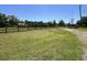 Expansive green lawn leading to a log cabin home with a red roof at 6935 Hickorynut Ln, Ravenel, SC 29470