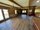 Open-concept room with hardwood floors, wood-beamed ceiling, stone fireplace, and an antler chandelier at 6935 Hickorynut Ln, Ravenel, SC 29470