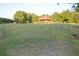 Spacious grassy field with a charming log home and fencing at 6935 Hickorynut Ln, Ravenel, SC 29470