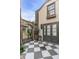 Beautiful backyard featuring checkerboard tiles, brick accents, an arched entrance, and stylish doors at 70 King St, Charleston, SC 29401