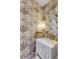 Chic powder room featuring custom floral wallpaper, a brass faucet, and a decorative vanity at 70 King St, Charleston, SC 29401