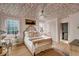 Bright, sunlit bedroom featuring hardwood floors, decoratively-papered ceiling, and luxury linens at 70 King St, Charleston, SC 29401