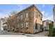 Stunning brick building with multiple windows, grey shutters, and a quaint tree-lined street at 70 King St, Charleston, SC 29401