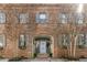 Beautiful brick facade with a central archway, a light blue door, and symmetrical flower boxes at 70 King St, Charleston, SC 29401