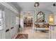 Bright foyer with hardwood floors, a vintage bench, view of dining room, and beautiful architectural details at 70 King St, Charleston, SC 29401