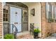 Charming front door with a light blue finish, decorative details, and wrought iron railings and flower box at 70 King St, Charleston, SC 29401