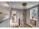 Bright hallway with a modern chandelier, hardwood floors, neutral walls, and natural light at 70 King St, Charleston, SC 29401