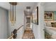 Bright hallway with decorative chandelier, wood floors, and views into the bedrooms at 70 King St, Charleston, SC 29401