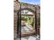 Lovely outdoor patio featuring checkerboard tiles, brick archway, stylish seating, and lush greenery at 70 King St, Charleston, SC 29401
