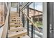 Modern staircase with sleek metal railings and wood treads, offering views of the backyard at 70 King St, Charleston, SC 29401