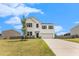 Inviting two-story home with a well-maintained lawn, a two-car garage, and a classic white facade at 715 Mcroy St, Moncks Corner, SC 29461
